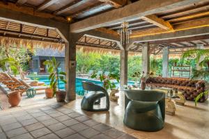 an outdoor patio with a couch and chairs and a pool at The Corduroy Hotel in Canggu