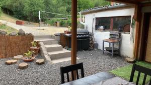 a backyard with a grill and stairs and a table at Nyugalmas Vendégház in Lénárddaróc