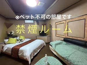 a room with two beds and writing on the wall at ホテルＪoＪo in Ikaho