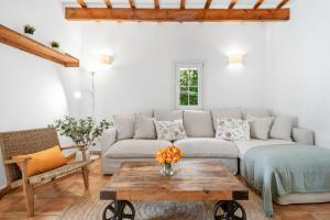 a living room with a couch and a table at Finca Biniatzau by 3VILLAS in Alaior