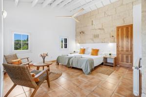 a bedroom with a bed and a table and chairs at Finca Biniatzau by 3VILLAS in Alaior