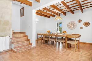 a dining room with a wooden table and chairs at Finca Biniatzau by 3VILLAS in Alaior
