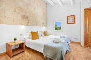 two beds in a room with white walls at Finca Biniatzau by 3VILLAS in Alaior +37 photos