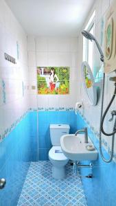a blue and white bathroom with a toilet and a sink at The cabana guesthouse in Cha Am