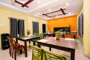 a dining room with wooden tables and chairs at Blooming Star in Mandarmoni