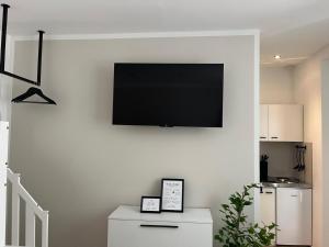 a flat screen tv hanging on a white wall at Zum Weinkrug - Apartments in Vienna
