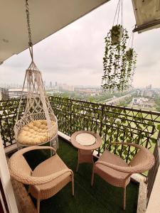 a balcony with chairs and a hammock and a view at R&R Eleanor Suites in Greater Noida