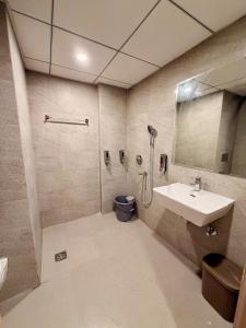 a bathroom with a sink and a mirror at R&R Eleanor Suites in Greater Noida +13 photos