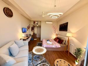 a living room with a couch and a bed at R&R Eleanor Suites in Greater Noida