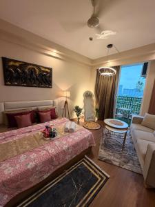 a bedroom with a bed and a couch and a living room at R&R Eleanor Suites in Greater Noida