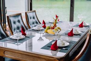 a dining table with red napkins and glasses on it at Vietnam Venture Cruises in Cat Ba +34 photos