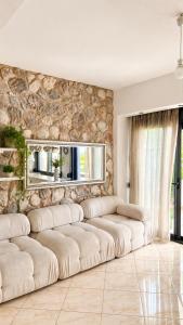 a living room with couches and a stone wall at Villa with Private Pool by the coast of Olympus in Leptokarya