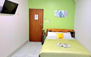a bedroom with a bed with a green wall at The cabana guesthouse in Cha Am