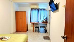 a bedroom with a bed and a desk and a table at The cabana guesthouse in Cha Am +18 photos