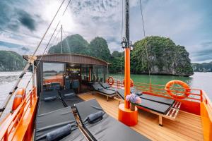 a boat with chairs and tables on the deck at Vietnam Venture Cruises in Cat Ba