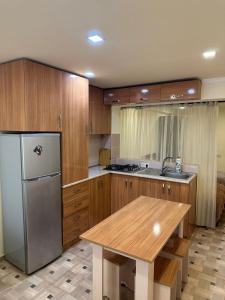 a kitchen with a stainless steel refrigerator and a table at Villa hills II in Yerevan