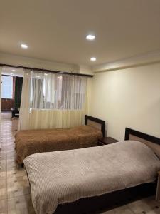a bedroom with two beds and a window at Villa hills II in Yerevan