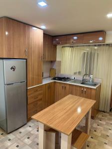 a kitchen with wooden cabinets and a wooden table and a refrigerator at Villa hills II in Yerevan