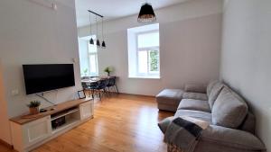a living room with a couch and a flat screen tv at Lossi 32 Lux Apartment in Tartu