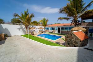 a house with a swimming pool and palm trees at Hotel Cantinho in Montanha