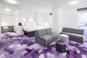 a bedroom with a bed and a couch and a chair at YOTEL Amsterdam in Amsterdam +79 photos