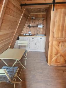 a kitchen with wooden walls and a table and chairs at Glamping cabins in Gorenja Vas