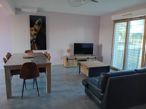 a living room with a table and a couch at Le Cottage d'Aubigny in Aubigny-sur-Nère