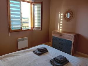 a bedroom with a bed with two towels on it at Le Cottage d'Aubigny in Aubigny-sur-Nère