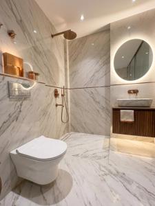a bathroom with a toilet and a sink and a mirror at Hotel De - Grand Villa Near Delhi IGI Airport in New Delhi
