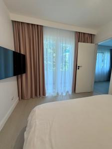 a bedroom with a bed and a flat screen tv at Apartament Amaya in Bistriţa