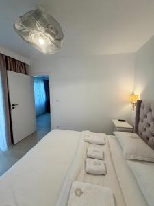 a large white bed in a bedroom with a light at Apartament Amaya in Bistriţa