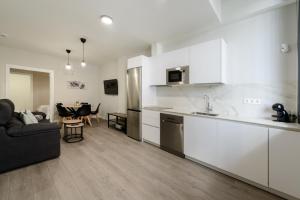 a kitchen and living room with a couch and a table at Torrejón Suites 2 in Torrejón de Ardoz +27 photos