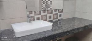 a bathroom with a white sink on a counter at 9 orchid Parbhat royal in Gobindgarh +18 photos