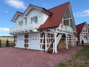 a house with two garage doors and a red roof at Villa Residenz am Vulkanradweg in Grebenhain