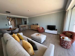 a living room with a couch and chairs and a television at Sand & Sea - Adults Only in Middelkerke