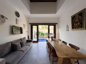 a living room with a couch and a wooden table at Amy Guesthouse Nusa Dua in Nusa Dua