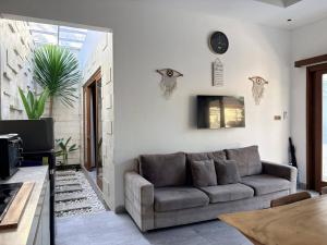 a living room with a couch and a table at Amy Guesthouse Nusa Dua in Nusa Dua