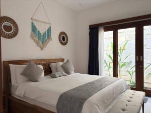 a bedroom with a large white bed and a window at Amy Guesthouse Nusa Dua in Nusa Dua +59 photos