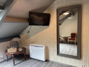 a mirror on a wall next to a room with a table at Grysperre B&B in Hooglede