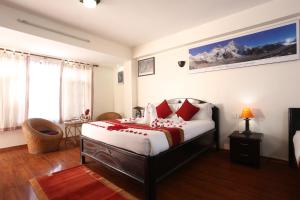 una camera da letto con un letto con cuscini rossi di Thamel Eco Resort a Kathmandu