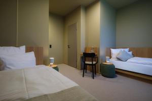 a hotel room with two beds and a chair at Haus Meeresstern in Wangerooge