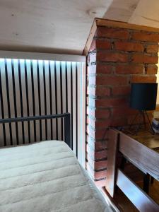 a room with a bed and a brick wall at ALBAK Green Zone in Gradačac