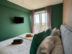 a bedroom with a bed with green walls and a window at Sand & Sea - Adults Only in Middelkerke