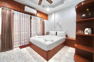 a bedroom with a white bed and a large window at Khun Ying House in Ko Tao