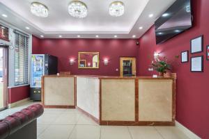 a bar in a restaurant with red walls at Cranbrook Hotel in Ilford +8 photos