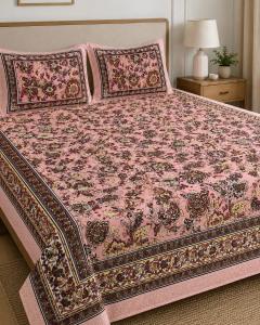 a bed with a pink blanket and pillows on it at Hotel Lomontreey in Kākori