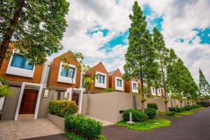 a row of houses on a street with trees at HARRIS Hotel & Conventions Malang in Malang