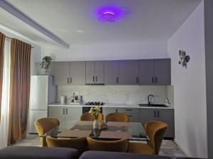 a kitchen with a table and chairs and a kitchen with white cabinets at Apartamente 2026 in Fălticeni