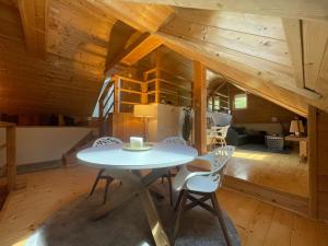 a table and chairs in a room with wooden ceilings at Chalet Notschkerl in Waasen