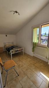 a room with a bed and a chair and a window at Nonna Marisa B&B in Madonna di Fornelli